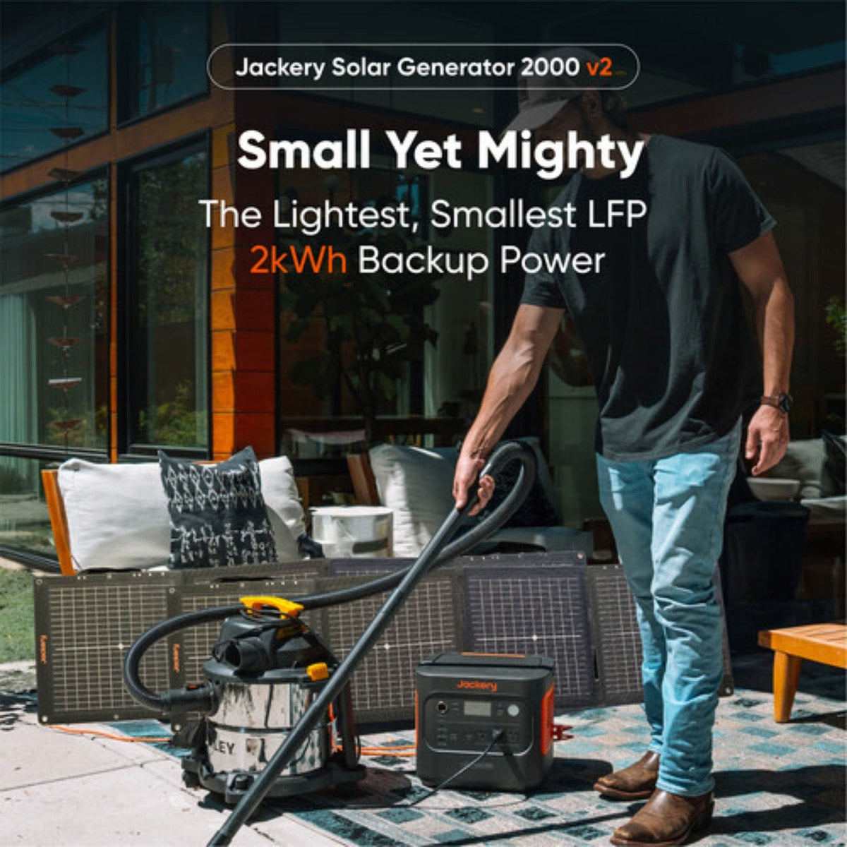 Jackery Explorer 2000 v2 Portable Power Station with vacuum plugged in and solar panel in the background